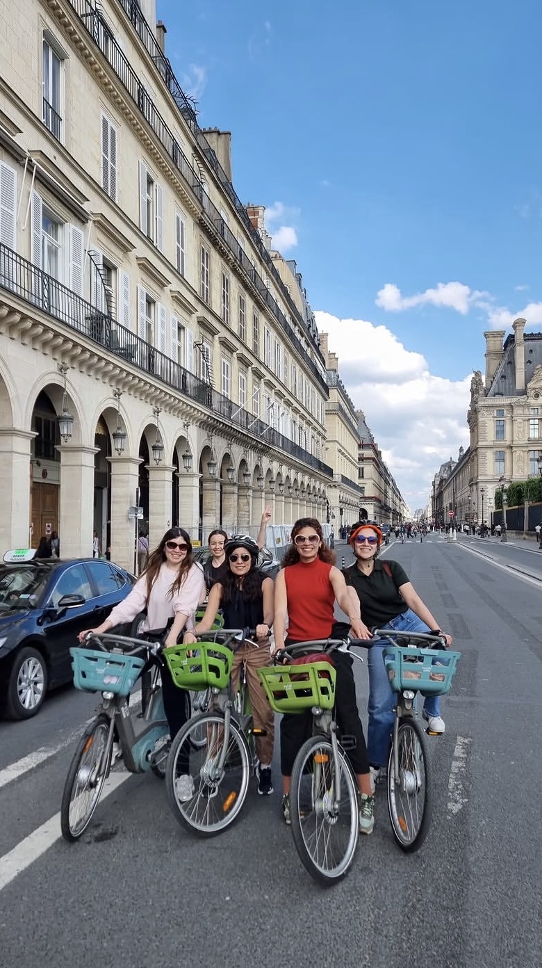 Amigas latinas paseando en bicicleta por la ciudad